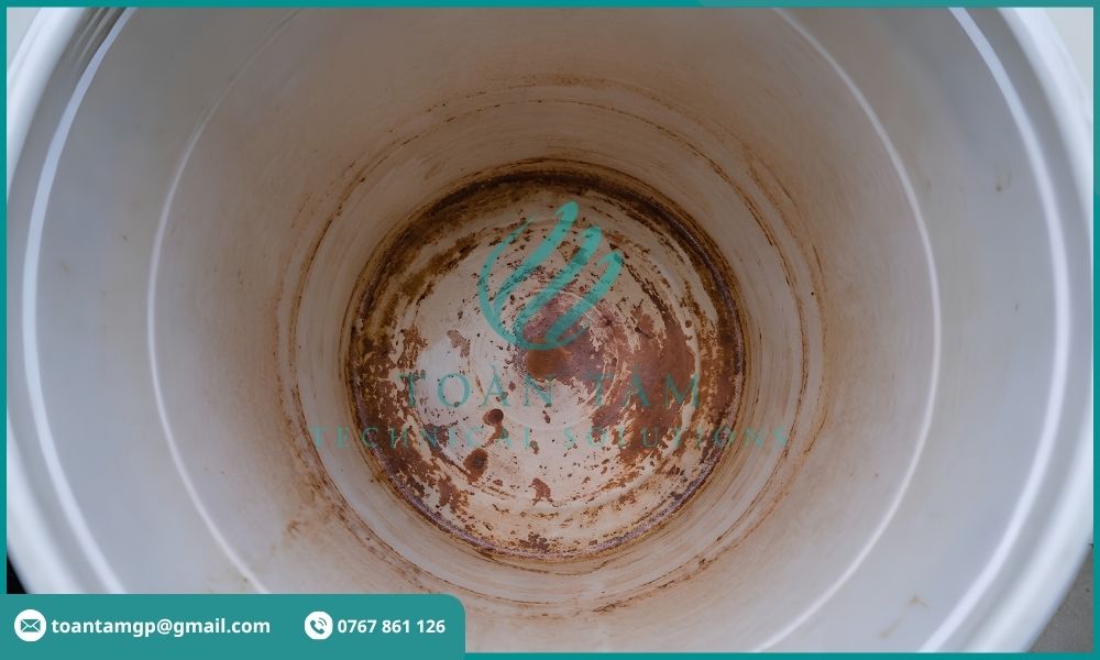 Cặn sắt màu nâu đỏ tích tụ dưới đáy xô